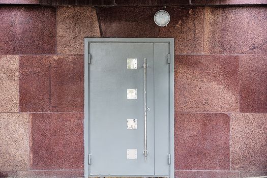 Metallic door at the marble wall