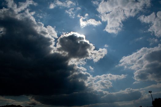 Sun behind clouds in summer