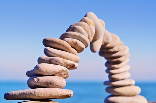 Arch of white pebbles on sky background