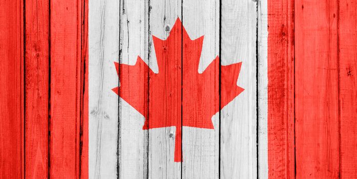 The Canadian flag painted on a wooden fence