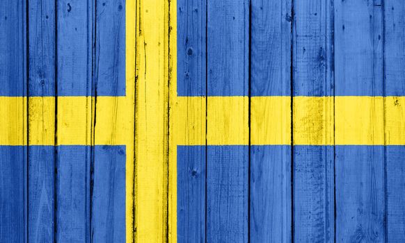 The Swedish flag painted on a wooden fence