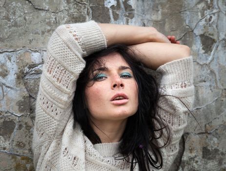 Portrait of a girl against old concrete wall