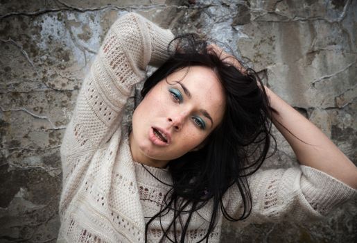 Portrait of a girl against old concrete wall