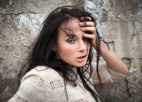 Portrait of a girl against old concrete wall