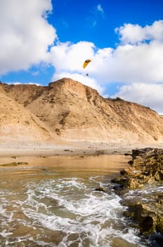 Flying paraglider above Mediterranean sea in Israel