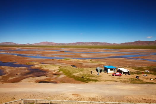 A small outpost at the Tibetan Plateau with mountain landscape in the background