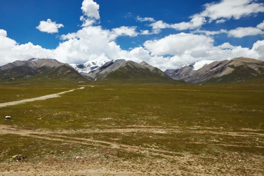 Green plains with mountain landscape at the Tibetan Plateau