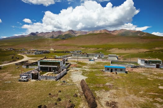 A Tibetan rural village in the outskirts.  Mountain landscape with cloudy sky