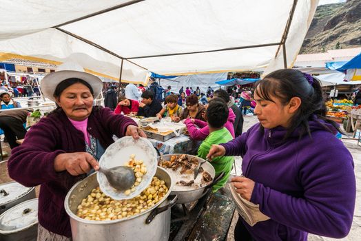 Pisac, Peru - July 14, 2013: Women cooking at Pisac market in the peruvian Andes at Pisac Peru on july 14th 2013