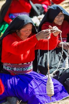 Puno, Peru - July 25, 2013: woman weaving in the peruvian Andes at Taquile Island on Puno Peru at july 25th, 2013.