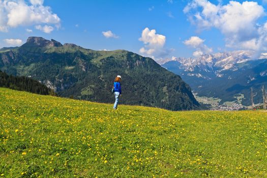 hiker on flowered meadow in Val di Fassa, Trentino, Italy - MR attached