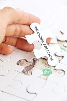 hand holding a puzzle piece, financial freedom concept