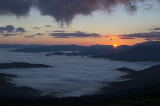 Sunrise in the mountains above the clouds