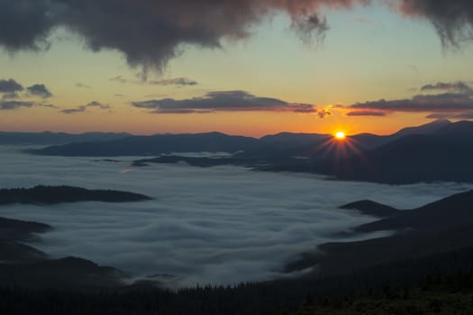 Sunrise in the mountains above the clouds