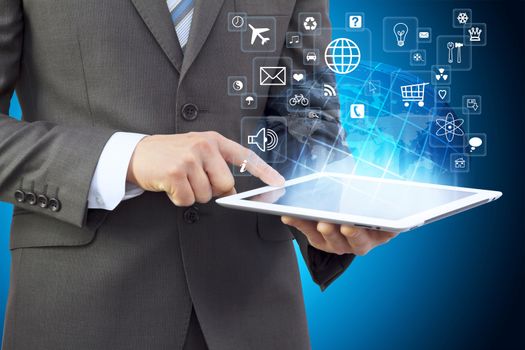 Businessman in a suit holding a tablet computer. Application icons are emitted from the tablet