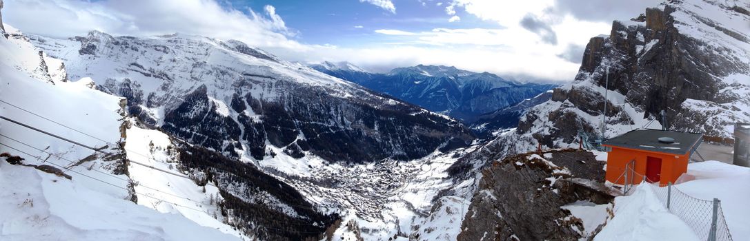 Panoramic composition of Leukerbad (Loeche les bains) village viewed from Gemmi pass in Alps mountain by winter with snow, Switzerland