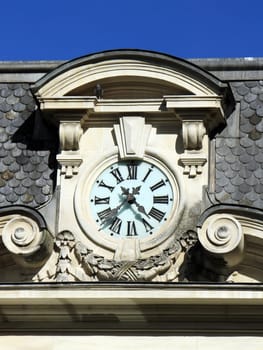 Close up of a clock on old building roof by beautiful day