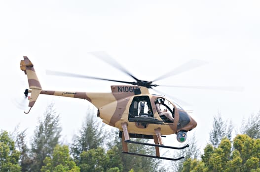 SINGAPORE - FEBRUARY 11: Boeing AH-6i light attack helicopter taking off at Singapore Airshow, Changi Exhibition Centre in Singapore on February 11, 2014.