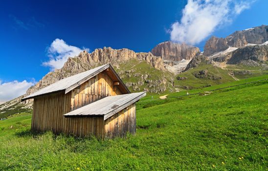 small barn beneath Dolomites mountains, Pordoi pass, Trentino, Italy