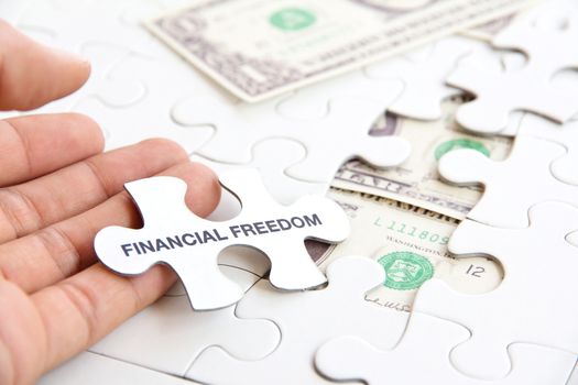 hand holding a puzzle piece, financial freedom concept