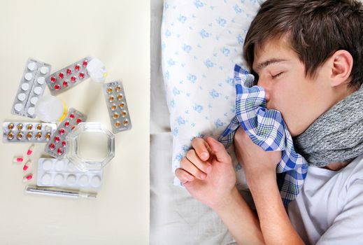 Sick Young Man sleeping on the Bed near the table with a pills