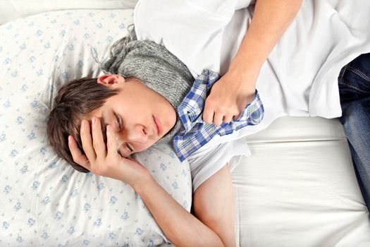 Sick Young Man feels Headache and lying on the Bed