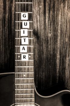 Acoustic guitar in vintage style on wood texture background