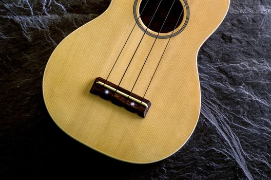 ukulele against a stone  background.