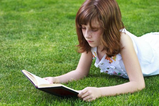 Park.Young beautiful girl reading a book outdoor