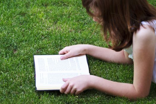 Tale.Young beautiful girl reading a book outdoor