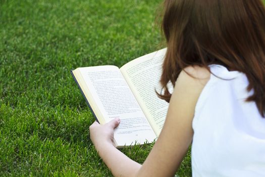 Student.Young beautiful girl reading a book outdoor