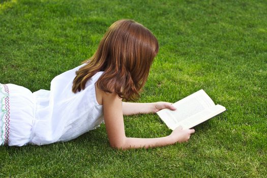 One.Young beautiful girl reading a book outdoor