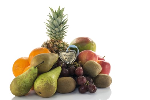 fruit as oranges pineapple grapes and kiwi isolated on white with thinking of you plate