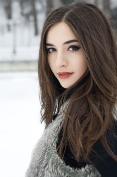 A brunette model posting in an outdoor environment.