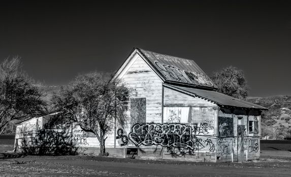 Dilapidated and Abandoned Farm House Marked with Graffiti in the United States in Black and White