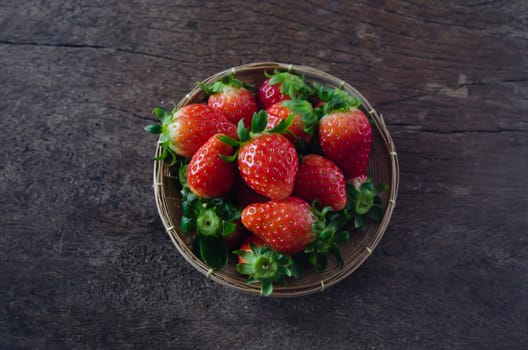 top view Fresh strawberries on basket  , over  old wooden background