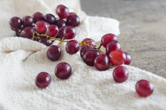 red grape on  sackcloth over wooden background