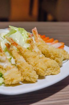 deep fried shrimp and  fresh vegetable salad on white dish