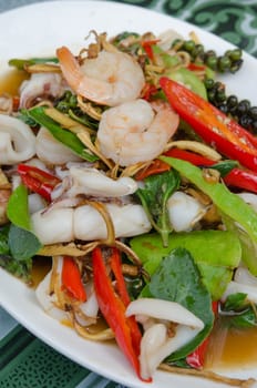 fried  mix seafood  with herbal vegetables on white plate