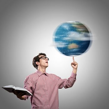 young man with a book thinks. keeps the finger symbol of the planet Earth. NASA images used