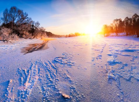 Sunrise over the frozen river - winter landscape