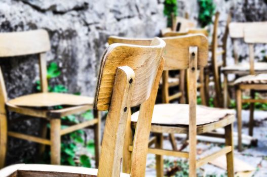 Vintage old school chairs rotting in a backyard, shallow depth of field