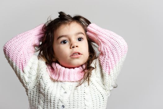 Adorable little girl arranging her hair