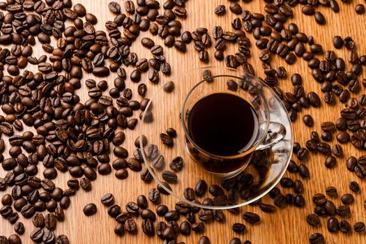 Coffee cup on wooden table with coffee beans