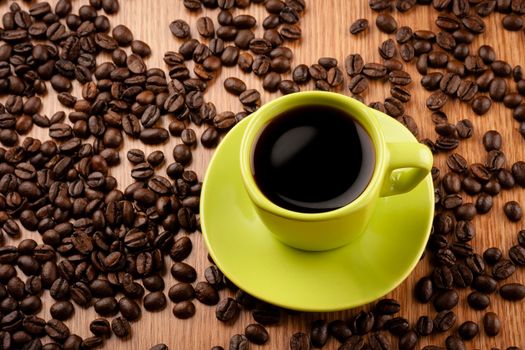 Coffee cup on wooden table with coffee beans