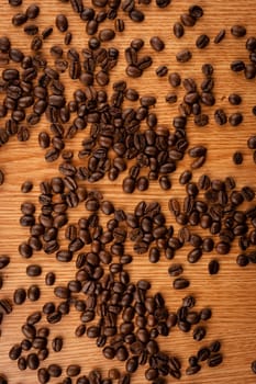 Scattered coffee beans on wooden table