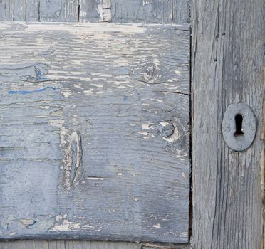 An antique wooden door with rusty keyhole in need of restoration
