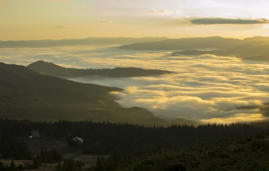 Dawn in the mountains above the clouds and the village