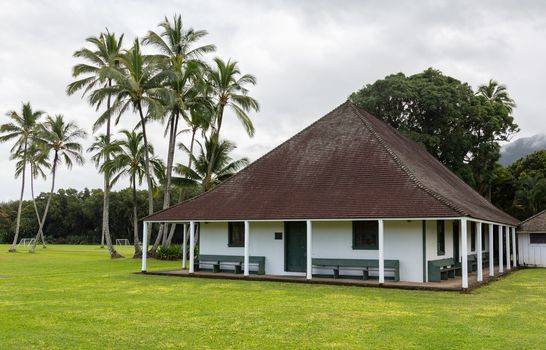 The old Waioli Huiia Mission building and hall in Hanalei Kauai with the Na Pali Mountains shrouded in mist in the background