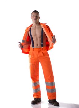 Full body shot of athletic young construction worker with orange suit open on naked torso